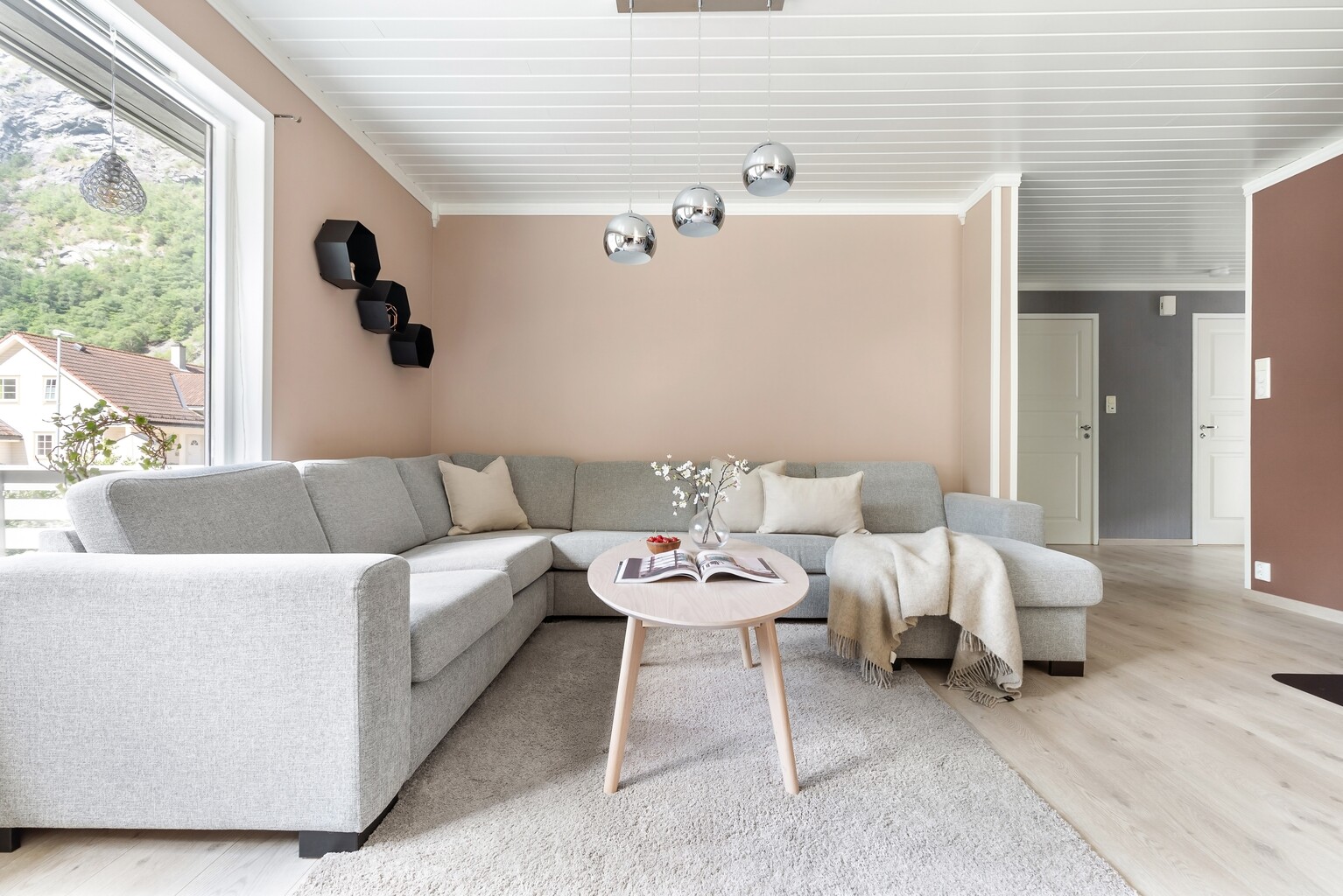 An occupied living room with a large corner sofa