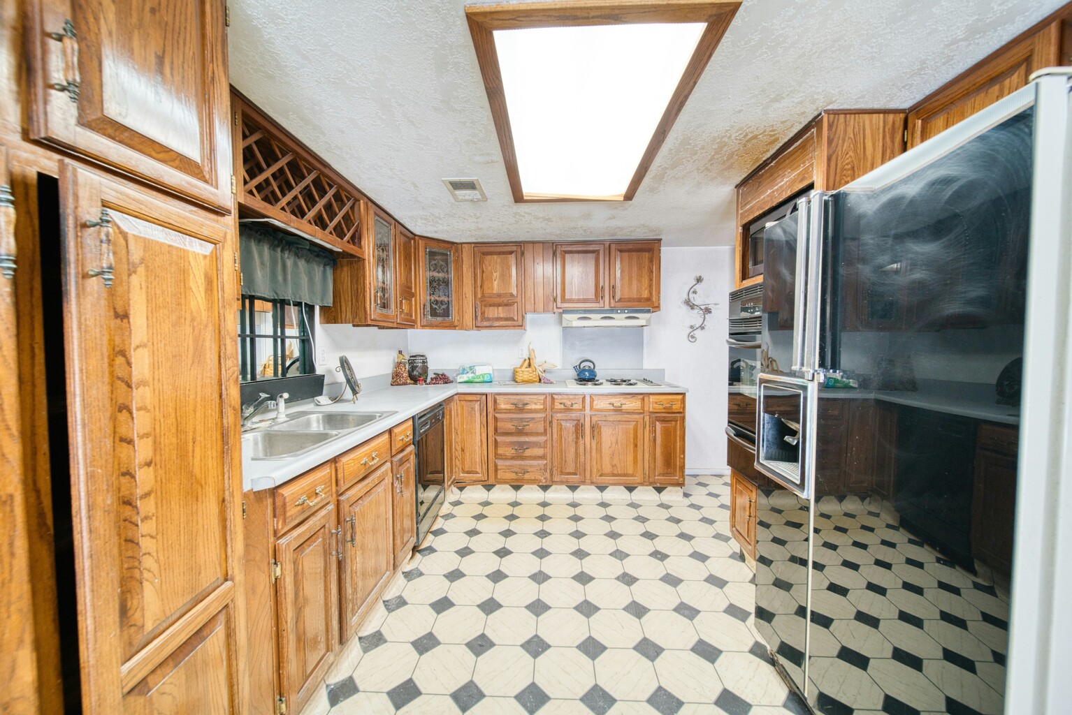 A dated galley kitchen with patterned flooring